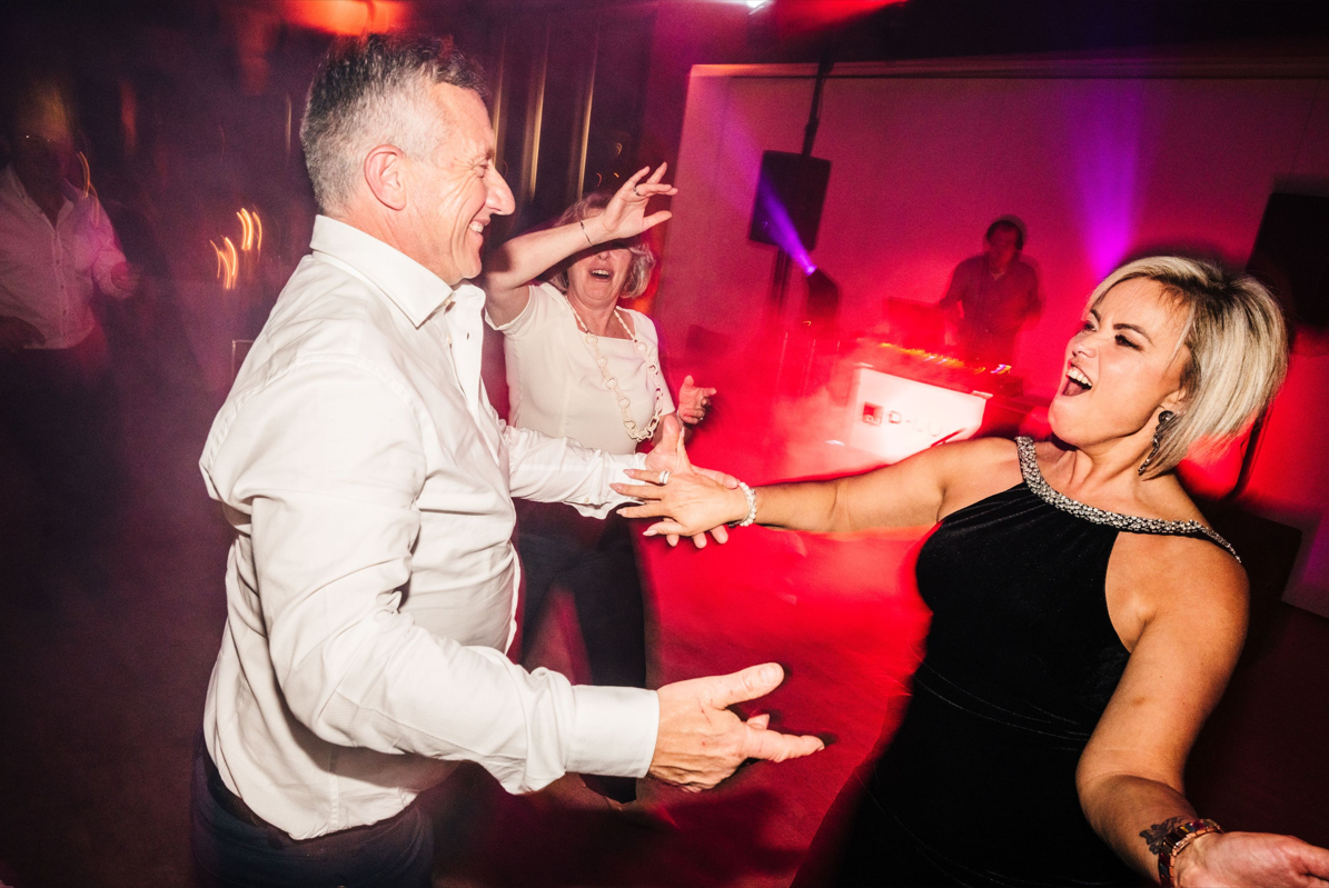 Uitbundige gasten dansen in rood licht