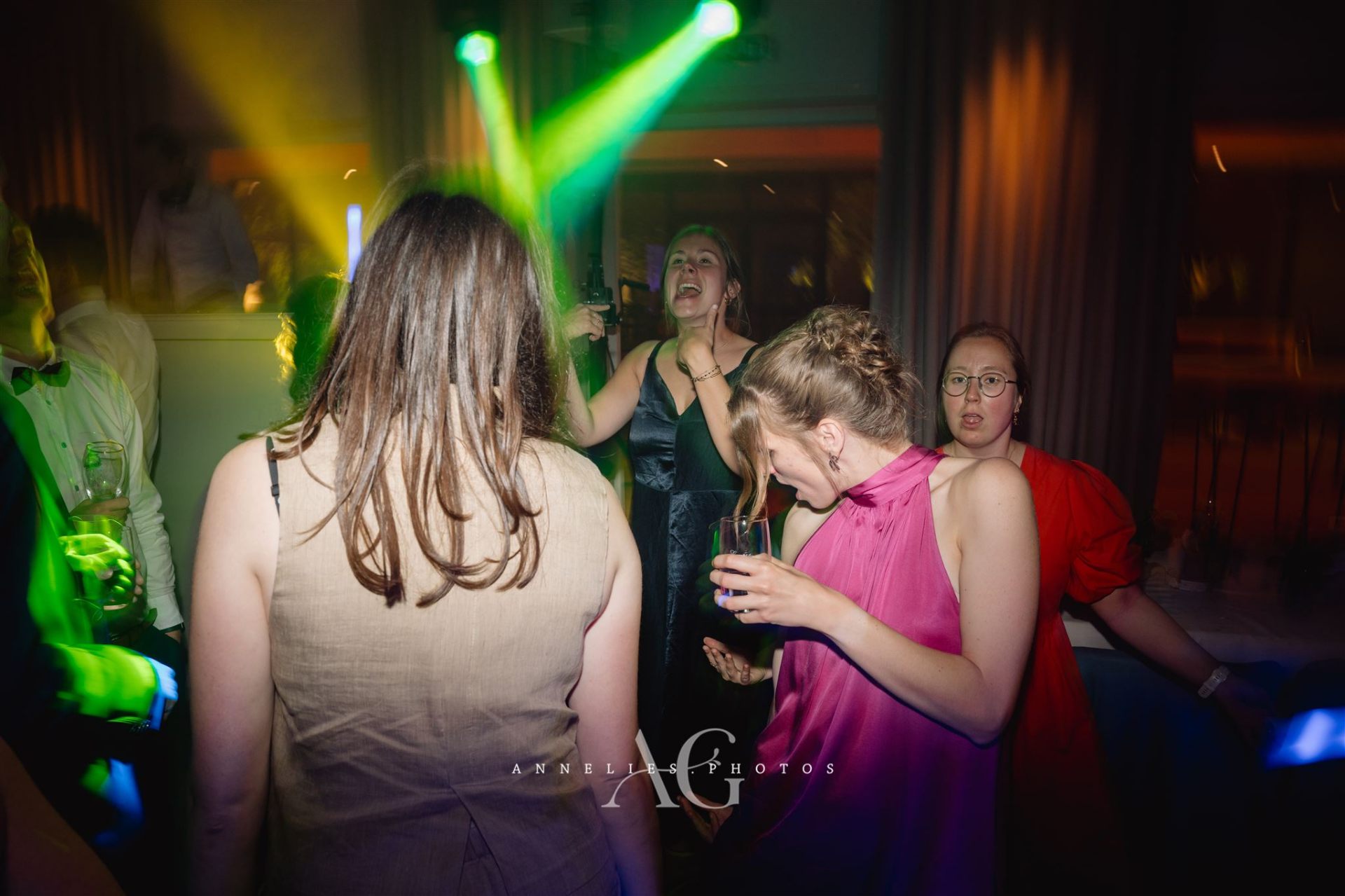 Vriendinnen dansen in groen en roze licht