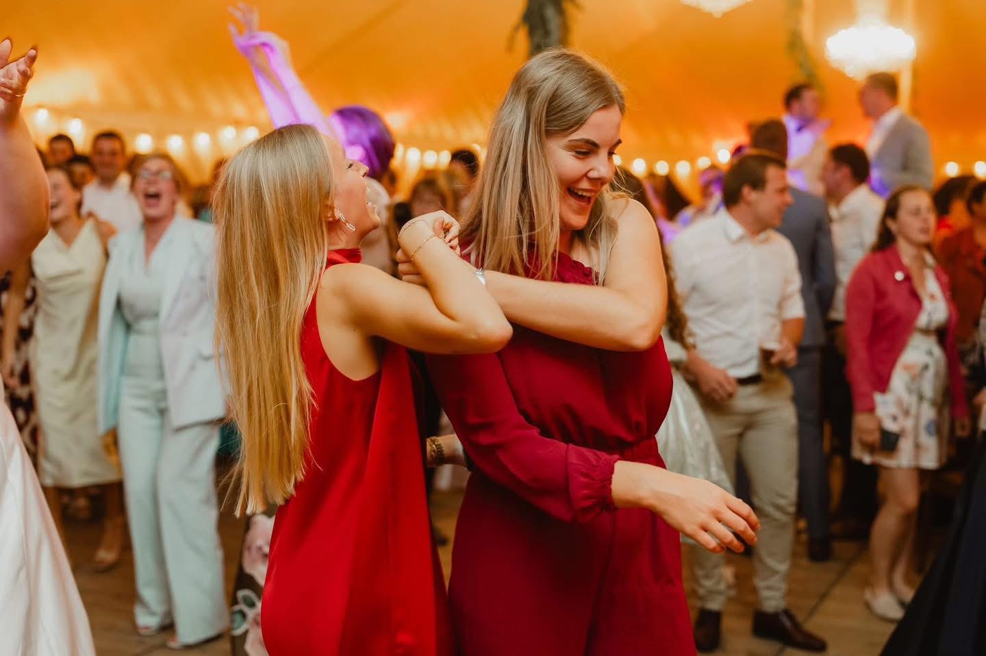 Vriendinnen omhelzen elkaar op feest in tent