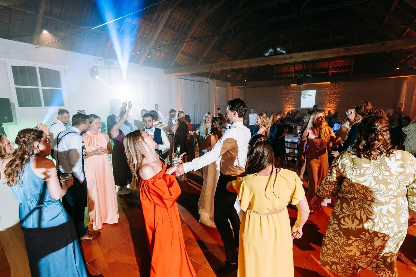 Volle dansvloer in schuur met spotlights