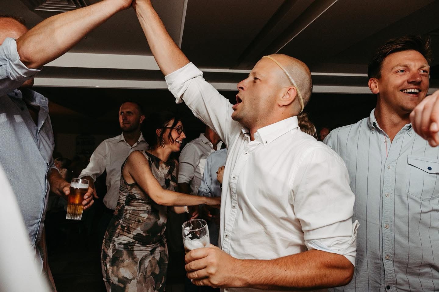 Zingende gast met opgeheven arm op feest